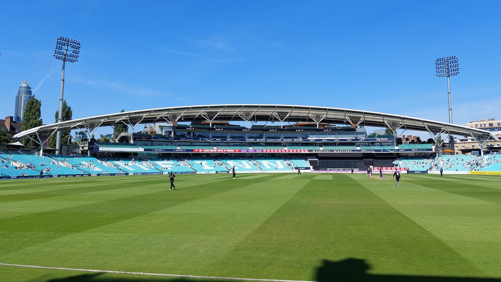 The curved roof and seating of the JM Finn Stand at The Oval, seen across the cricket field in August 2022